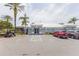 Exterior of community clubhouse with ample parking, golf cart and mature landscaping at 8204 Fan Palm Way, Kissimmee, FL 34747