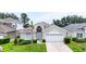 Charming single-story home featuring an attached two-car garage and mature landscaping at 8204 Fan Palm Way, Kissimmee, FL 34747