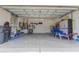 Spacious two car garage with overhead storage, shelving, and a clean epoxy floor at 8204 Fan Palm Way, Kissimmee, FL 34747