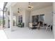 A covered patio with ceiling fans, outdoor seating and a sliding glass door to the interior at 8204 Fan Palm Way, Kissimmee, FL 34747
