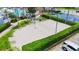 Aerial image of the sand volleyball court featuring a net, and is surrounded by manicured landscaping at 8204 Fan Palm Way, Kissimmee, FL 34747