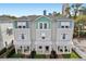 Aerial view of townhomes with a mix of gray and blue tones, complemented by lush landscaping and metal roofs at 117 E Concord St # 8, Orlando, FL 32801