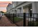 Charming townhomes featuring brick sidewalks, black metal fencing, and welcoming covered entrances at 117 E Concord St # 8, Orlando, FL 32801