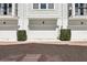 Exterior view of townhome garages featuring low shrubs and brick driveways at 117 E Concord St # 8, Orlando, FL 32801