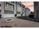 Exterior view of attached garages with brick driveway and well-maintained landscaping at sunset at 117 E Concord St # 8, Orlando, FL 32801