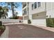 Townhome with two-car attached garage, brick-paved driveway, trimmed bushes, and a view of the second story balcony at 117 E Concord St # 8, Orlando, FL 32801