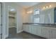 Bathroom showcasing dual sinks, granite countertops, and ample cabinet space, plus a walk-in closet at 13041 Gabor Ave, Orlando, FL 32827