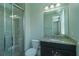 Shot of a bathroom with a glass shower, a dark cabinet and a granite countertop at 13041 Gabor Ave, Orlando, FL 32827