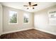 Shot of a bedroom with a ceiling fan, wood floors and windows providing ample natural light at 13041 Gabor Ave, Orlando, FL 32827