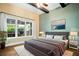 Comfortable bedroom with hardwood floors, a large bed, and views of the outdoor cooking area at 13041 Gabor Ave, Orlando, FL 32827