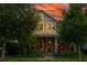 Charming two-story home with gray siding, stone accents, and lush landscaping against a vibrant sunset sky at 13041 Gabor Ave, Orlando, FL 32827