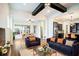 Open-concept living room with dark wood beams, comfortable seating, and seamless flow to the kitchen and dining area at 13041 Gabor Ave, Orlando, FL 32827