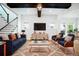 Beautiful staged living room with a large area rug, sofa, 2 chairs, TV, and console table at 13041 Gabor Ave, Orlando, FL 32827