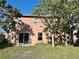 Exterior shot of the backyard, with trees, grass, and a view of the house's rear at 1322 Aguacate Ct, Orlando, FL 32837