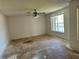 A vacant living room with a window and ceiling fan awaits new flooring at 1322 Aguacate Ct, Orlando, FL 32837