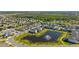 A wide aerial view showcasing a residential neighborhood with pond and fountain on a sunny day at 14321 Wabasso Loop, Winter Garden, FL 34787