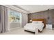 Bright bedroom with modern fixtures, textured accent wall, and natural light from the window at 14321 Wabasso Loop, Winter Garden, FL 34787