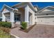 Close up of charming two-story home with well-manicured landscaping and brick-paved walkway at 14321 Wabasso Loop, Winter Garden, FL 34787