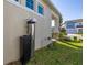 Side view of a home featuring lawn, garden bed and a modern water filtration system at 14321 Wabasso Loop, Winter Garden, FL 34787