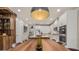 Spacious kitchen features white cabinets, stainless steel appliances, and a large wooden dining table at 14321 Wabasso Loop, Winter Garden, FL 34787