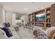 Bright living room features modern built-ins with a fireplace, large TV, and light gray color palette at 14321 Wabasso Loop, Winter Garden, FL 34787
