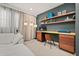 This home office features an inviting color scheme, an elegant desk, and custom shelving at 14321 Wabasso Loop, Winter Garden, FL 34787