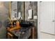 Elegant powder room with a decorative mirror, sleek black sink, and dark marbled countertop at 14321 Wabasso Loop, Winter Garden, FL 34787
