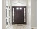 Elegant entryway with a black front door with sidelights, light tile flooring, and wall decor at 1718 Golfview Dr, Kissimmee, FL 34746