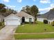 Traditional single-Gathering home with a well-manicured front yard and two-car garage at 1718 Golfview Dr, Kissimmee, FL 34746