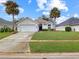 Charming single story home with two-car garage, lush lawn, and palm trees in a desirable neighborhood at 1718 Golfview Dr, Kissimmee, FL 34746