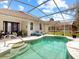 The covered, screened pool with steps leads to an outdoor relaxation area at 1718 Golfview Dr, Kissimmee, FL 34746