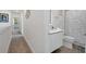 Stylish bathroom featuring a modern vanity, sleek toilet, and hallway leading to a bedroom at 17238 Blessing Dr, Clermont, FL 34714