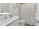 Bright bathroom with white finishes, featuring a shower with modern patterned shower curtain and vanity at 17238 Blessing Dr, Clermont, FL 34714
