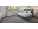 Cozy bedroom with a plush gray bed, soft carpeting, and ample natural light from a large window at 17238 Blessing Dr, Clermont, FL 34714