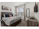 A modern bedroom featuring a queen bed, stylish decor, and a bright window at 17238 Blessing Dr, Clermont, FL 34714