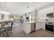 Modern kitchen with stainless steel appliances, white cabinetry, and an island that flows into the living area at 17238 Blessing Dr, Clermont, FL 34714