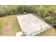 Aerial view of a private, fenced basketball court with two hoops, on a large lot with tall trees at 1783 Coriander Dr, Kissimmee, FL 34759