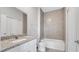 Bathroom featuring granite countertops, white cabinets, and a shower with tan tile at 1783 Coriander Dr, Kissimmee, FL 34759