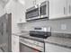Modern kitchen features stainless steel appliances, granite countertops, and white cabinets at 1783 Coriander Dr, Kissimmee, FL 34759