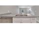 Kitchen island with stainless steel sink, granite countertops and white cabinets at 1783 Coriander Dr, Kissimmee, FL 34759