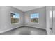 Bedroom with two windows providing exterior views, tile floors, and light gray walls at 1785 Coriander Dr, Kissimmee, FL 34759