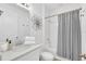 Cozy bathroom with single vanity, quartz countertop, and tub-shower with striped curtain at 2039 Derwent Dr, Davenport, FL 33896