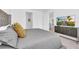 Bright bedroom featuring a gray quilted bedspread, decorative pillows, and a stylish dark-wood entertainment center at 2039 Derwent Dr, Davenport, FL 33896