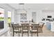 Contemporary dining area with a long wooden table, stylish chandelier, and a view to the kitchen at 2039 Derwent Dr, Davenport, FL 33896