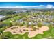 Lovely aerial view of homes backing to a lush golf course and a community sand trap, in a desirable neighborhood at 2105 Mallory Cir, Haines City, FL 33844