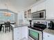 Bright kitchen featuring stainless steel appliances, granite counters, and white cabinets with ample storage at 2105 Mallory Cir, Haines City, FL 33844