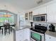 Bright kitchen featuring stainless steel appliances, granite counters, and white cabinets with ample storage at 2105 Mallory Cir, Haines City, FL 33844