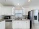 Bright kitchen featuring stainless steel appliances, granite counters, and white cabinets with ample storage at 2105 Mallory Cir, Haines City, FL 33844