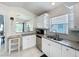 Bright kitchen featuring stainless steel appliances, granite counters, and white cabinets with ample storage at 2105 Mallory Cir, Haines City, FL 33844