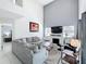 Bright living room featuring a fireplace, high ceilings, and large comfortable grey sofa at 2105 Mallory Cir, Haines City, FL 33844